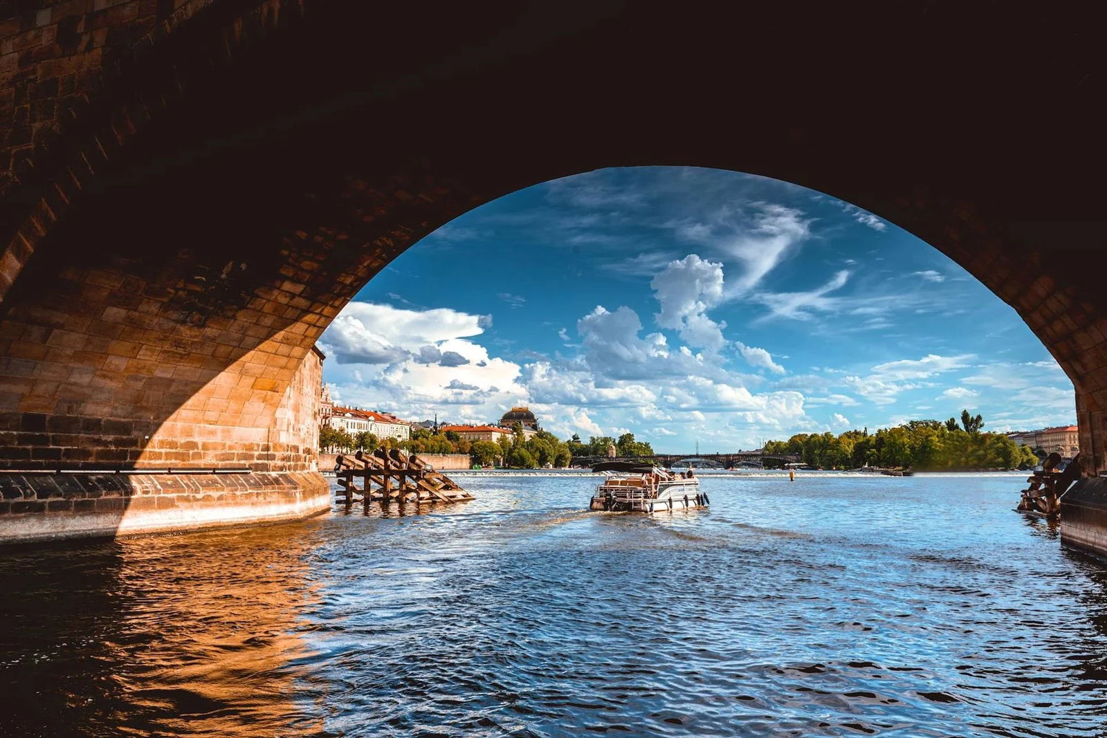 Vista desde un barco bajo el arco de un puente hacia el Moldava