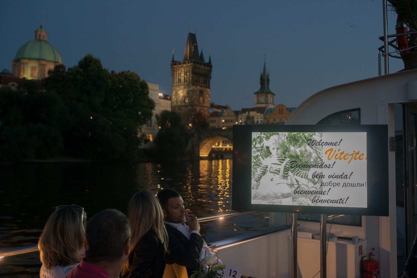 Ein Begrüßungsbildschirm an Deck am Abend an der Karlsbrücke