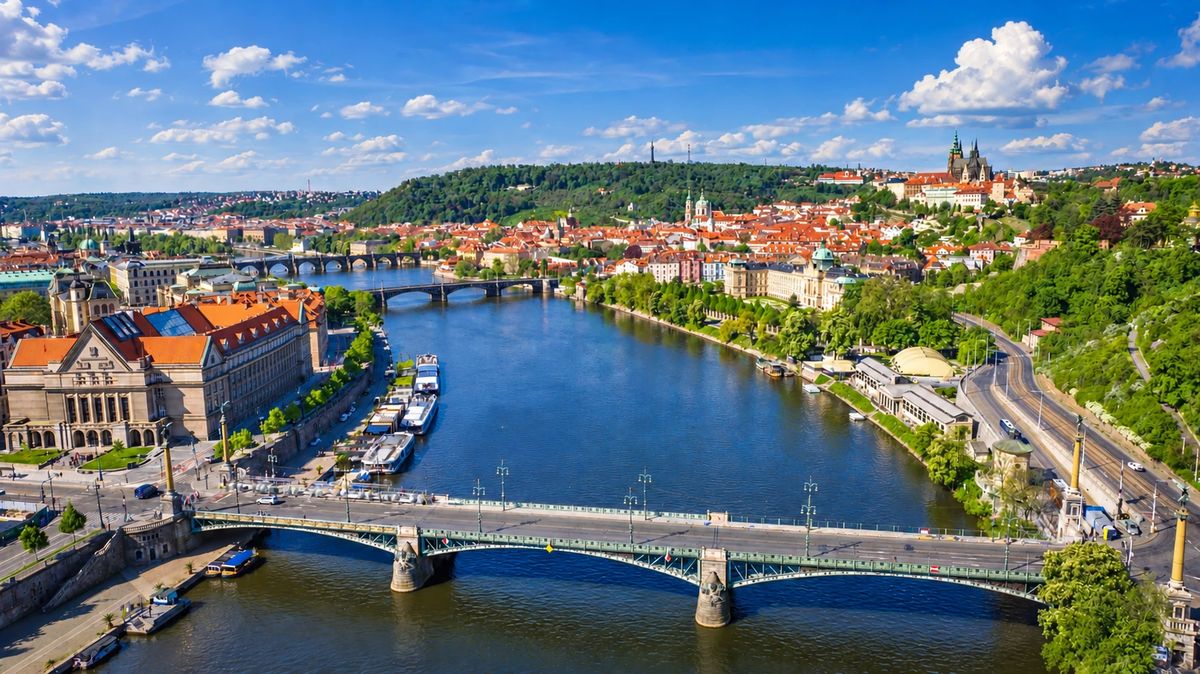 Aerial view of Čech Bridge and Dvořák Embankment with the Prague Boats piers; Prague Castle at the top right