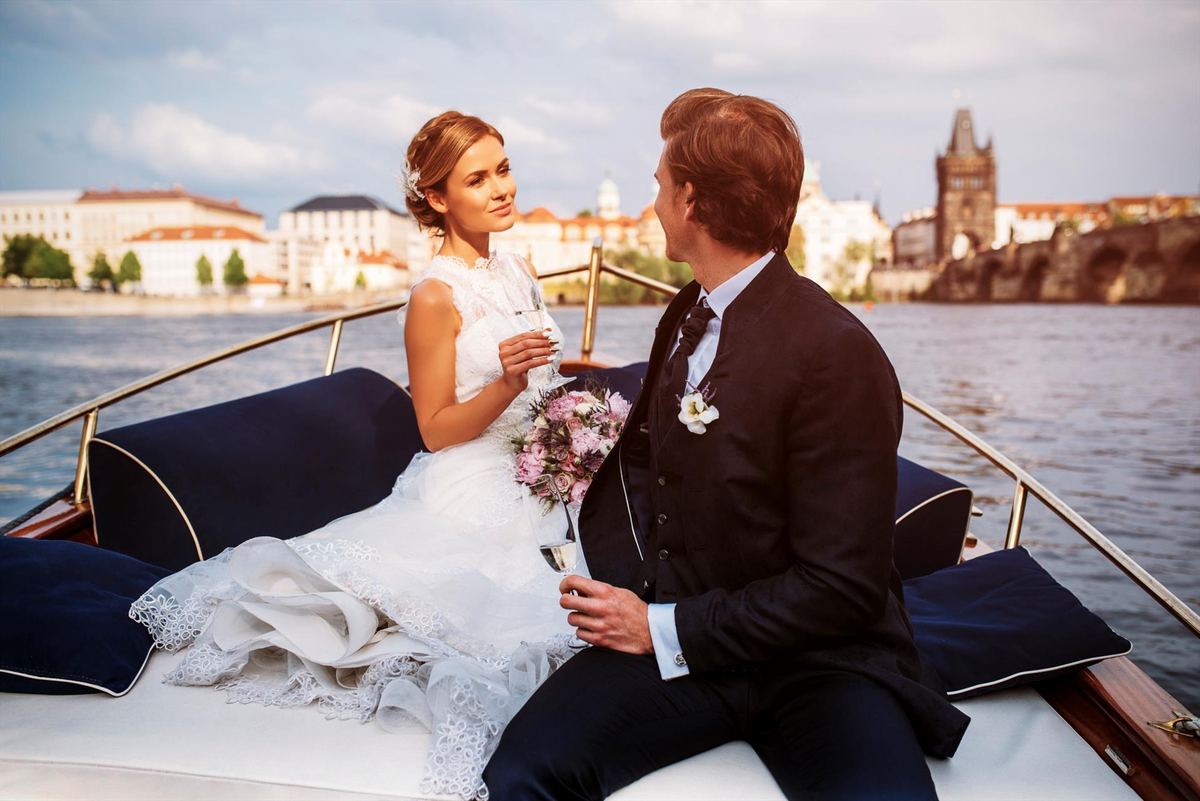 Recién casados en un pequeño barco de caoba en el Moldava