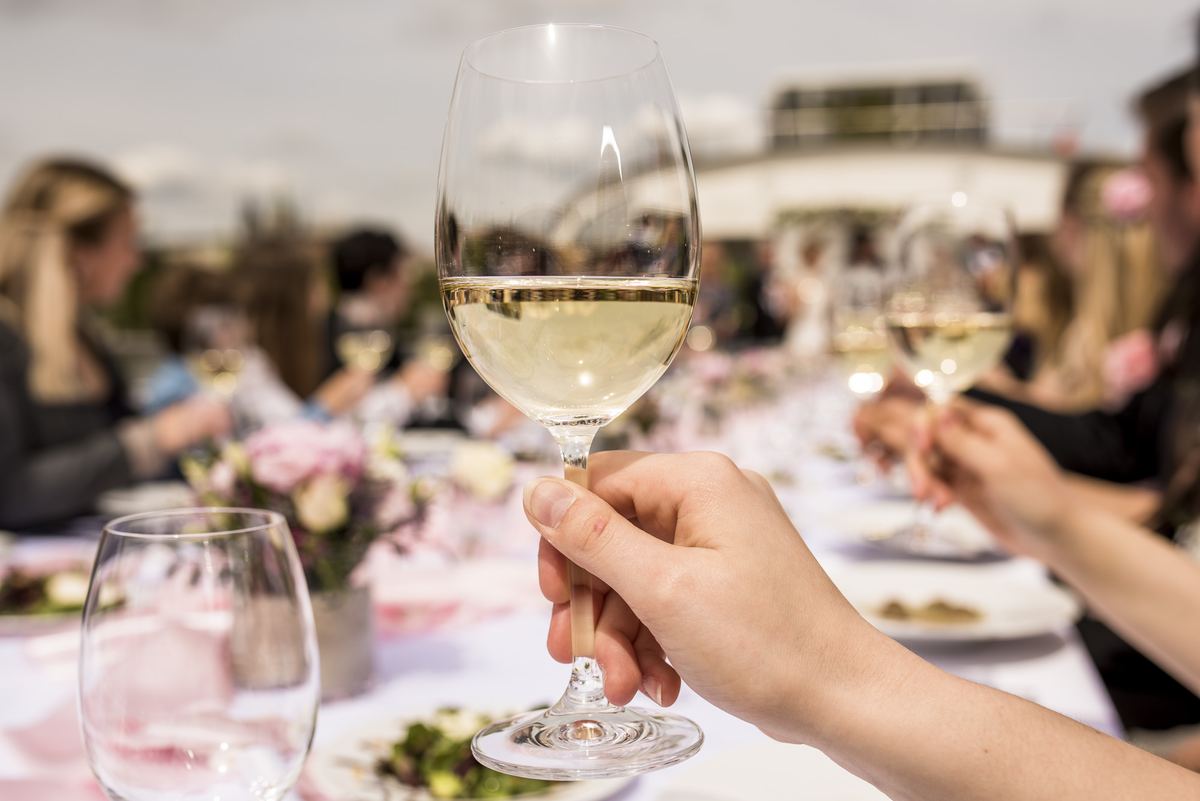 Brindis con vino blanco en la mesa de boda en un barco