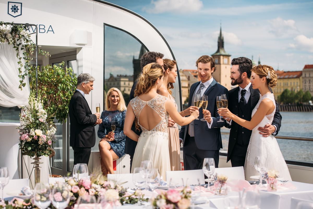 Brindis de boda con los invitados en la cubierta de un barco en Praga