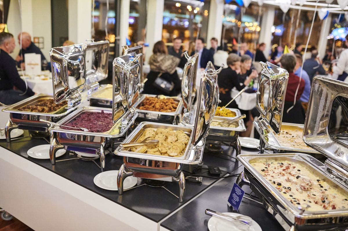 Warmes Buffet und Gäste an Tischen bei einer Firmenveranstaltung an Bord