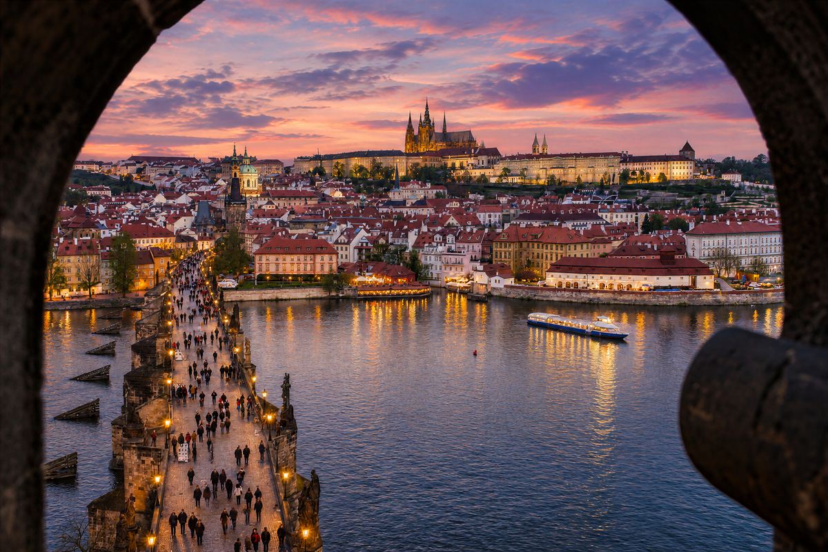 Vista desde la torre del puente del Puente de Carlos, el Castillo de Praga y un barco en el Moldava