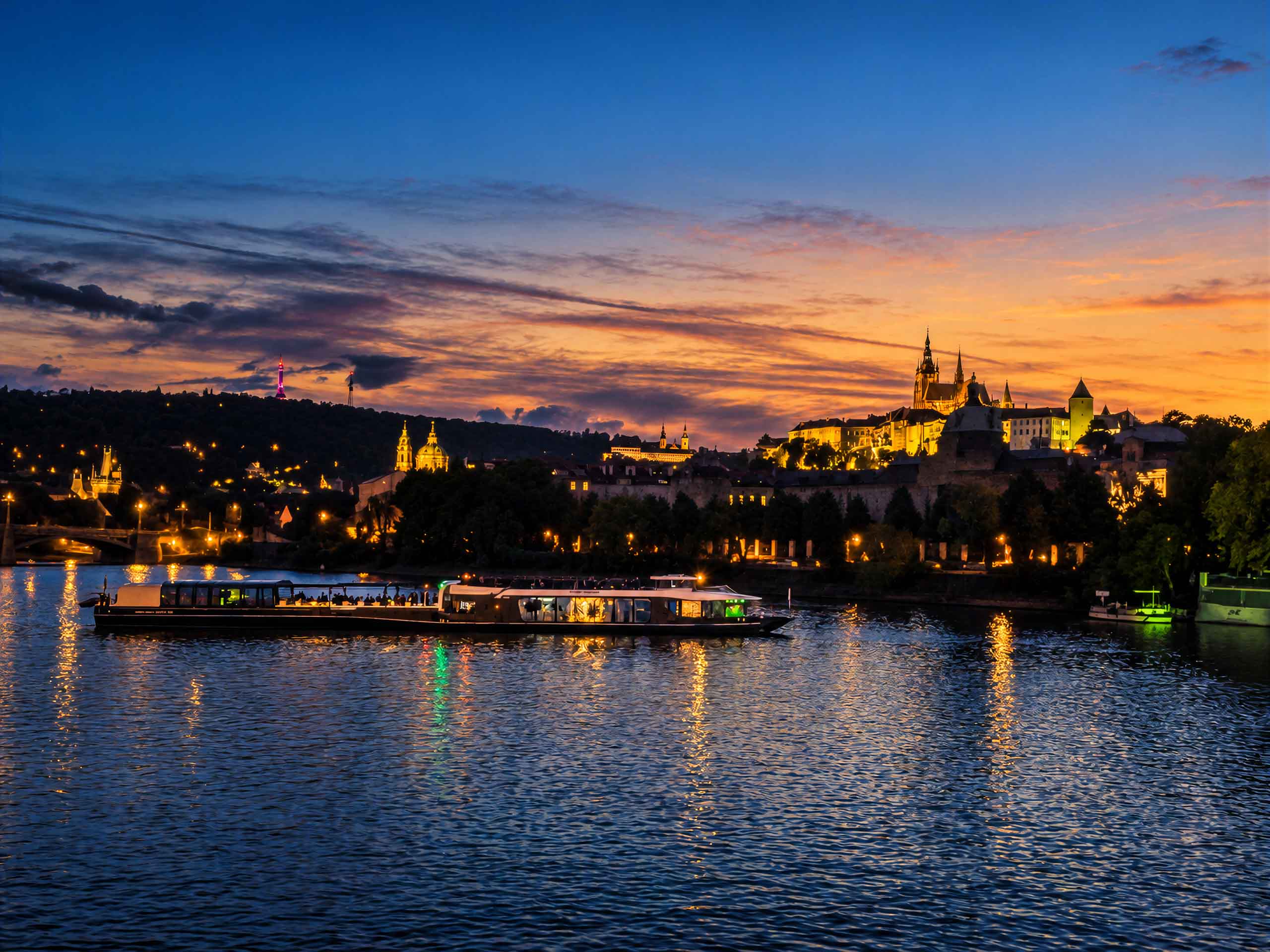 A boat on the river beneath the evening sky and Prague Castle