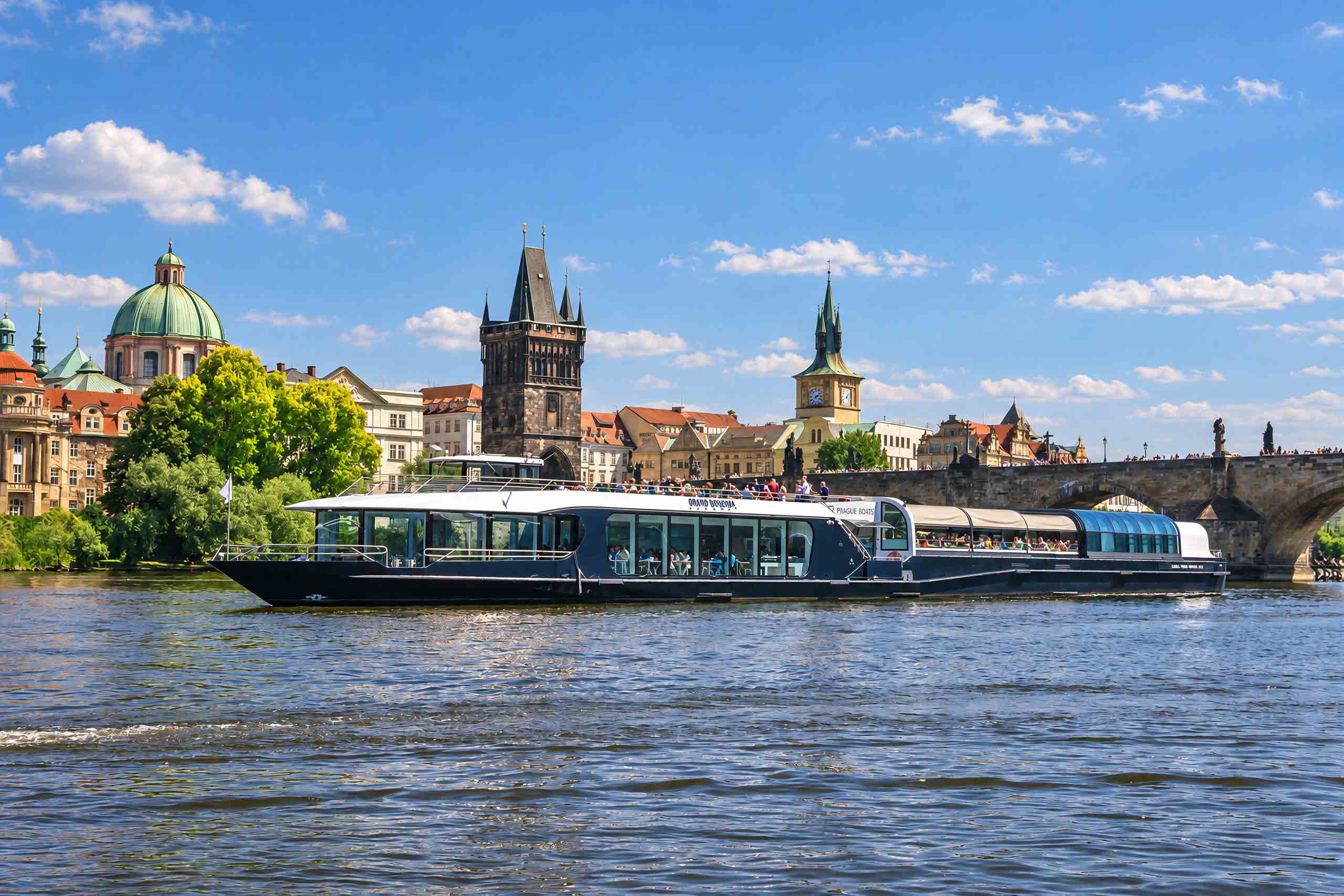 Sightseeing boat beside Charles Bridge in daylight