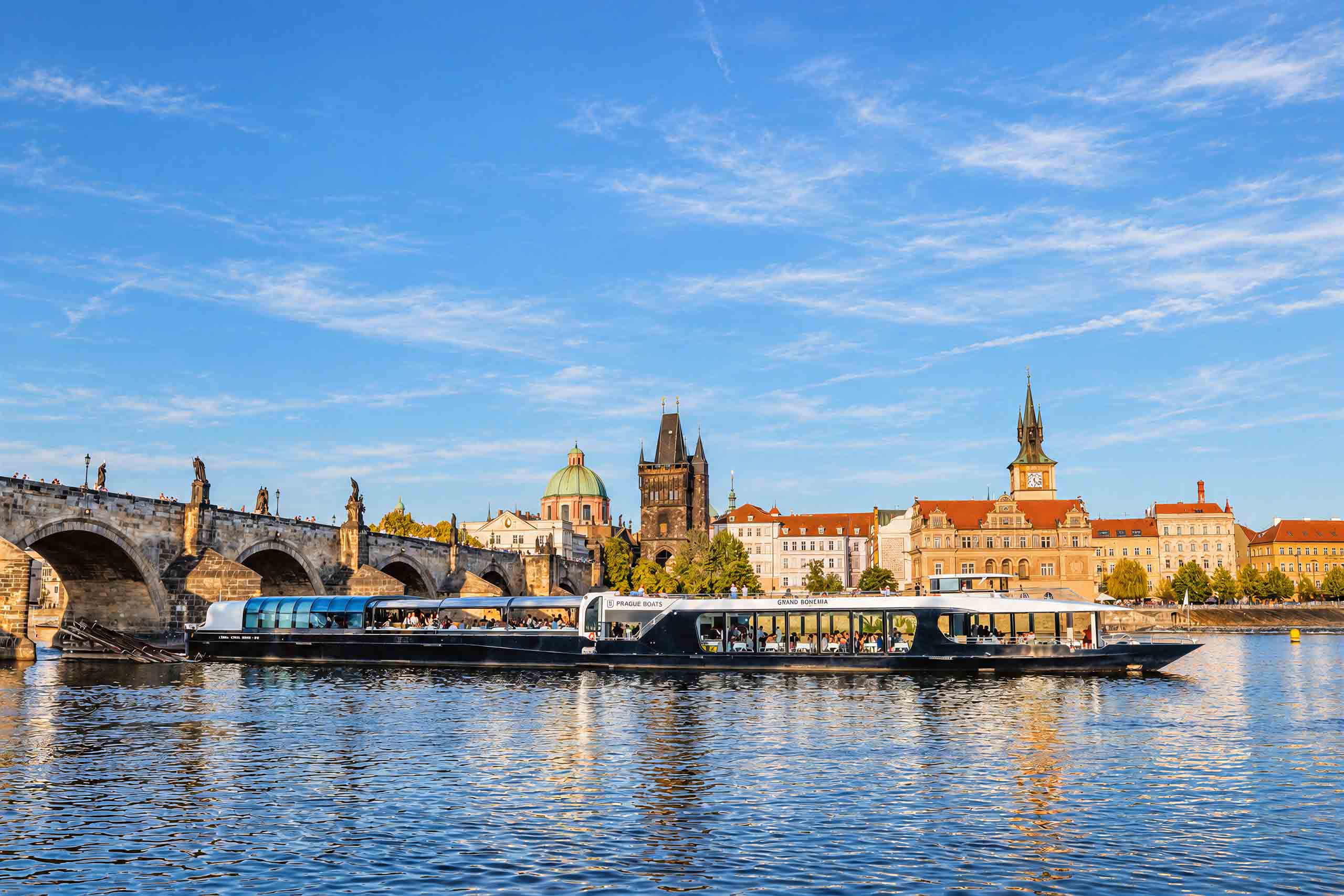 Sightseeing boat beside Charles Bridge in daylight
